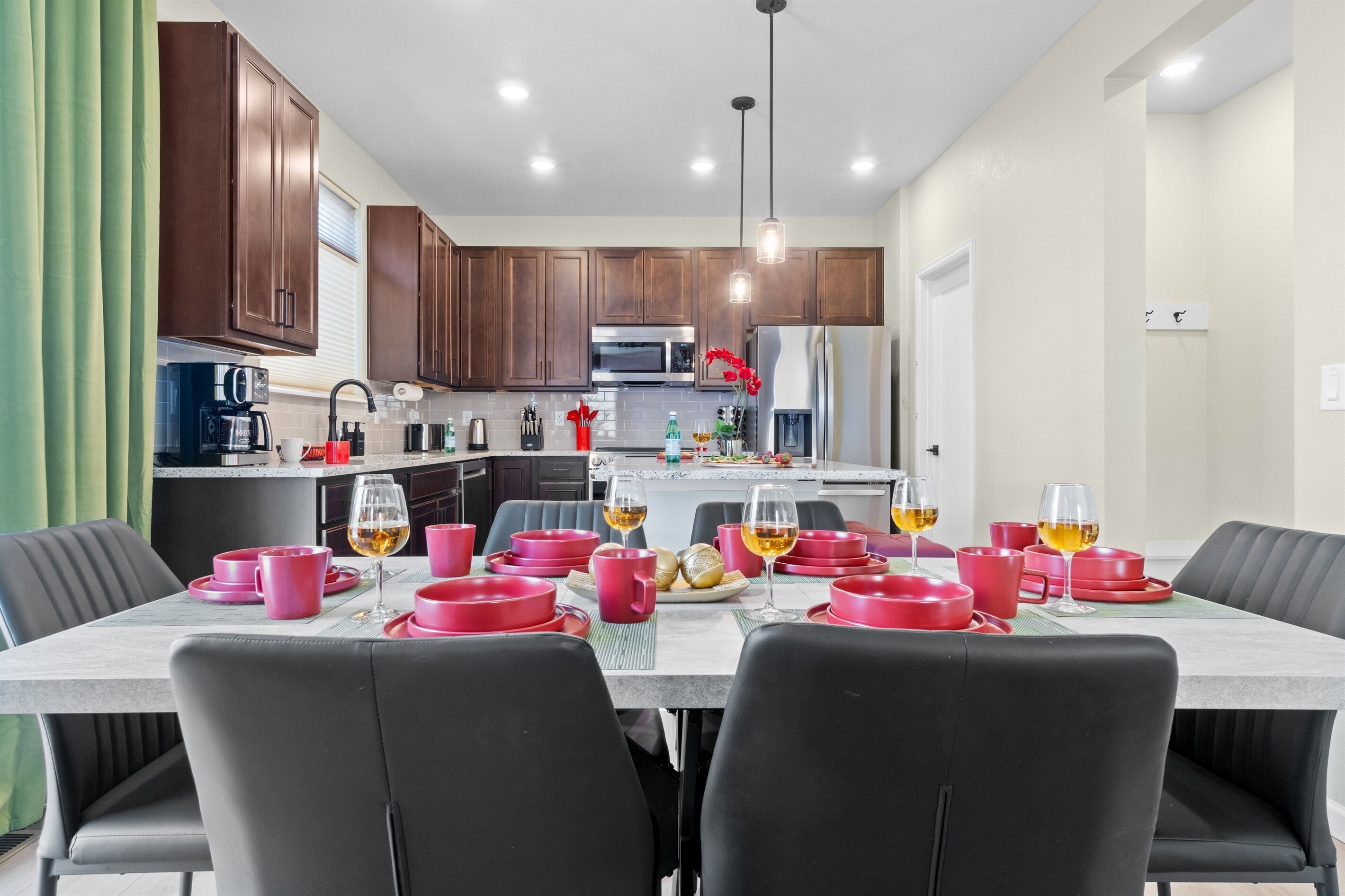 Una cocina moderna con armarios de madera, una isla central y un comedor listo para una comida.