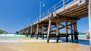 A wooden pier extending into the ocean with a clear sky above. - The Jetty Retreat - 1km from Jetty Beach (Coffs Harbour)