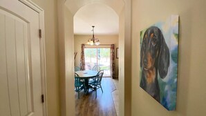 A hallway leading to a dining area with a table and chairs, a painting on the wall, and a door on the left. - Pool & Hot Tub! Close to Zion National Park and Bryce Canyon and hiking trails in Kanab, Utah! (Kanab)