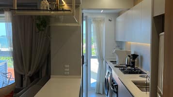 Apartamento lua de mel, acesso à piscina, vista para a praia | Cozinha privada | Geladeira, micro-ondas, talheres/pratos/utensílios de cozinha