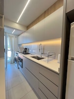 Apartamento lua de mel, acesso à piscina, vista para a praia | Cozinha privada | Geladeira, micro-ondas, talheres/pratos/utensílios de cozinha