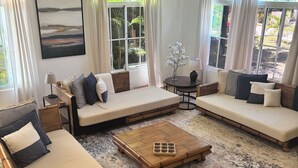 Un espace de vie spacieux comprenant un grand canapé, une table basse et une petite table d’appoint.