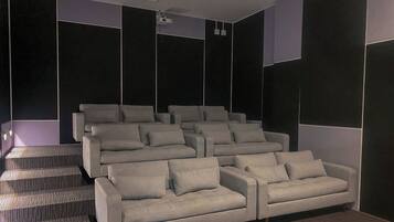 Una sala de cine moderna con butacas escalonadas y un proyector.