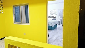 A hallway with yellow walls and a window with curtains. - SeaEsta Negril (Negril)