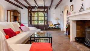 Una sala de estar acogedora con un sofá, una mesa de centro de vidrio, una chimenea y un techo de madera.