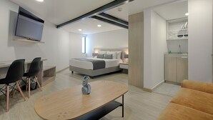 Une chambre à coucher moderne avec un lit, des tables de chevet et un téléviseur fixé au mur.
