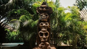 A stone structure with multiple faces, surrounded by lush greenery. - Kawabonga Hostel (Dibulla)