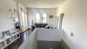 A spacious living area with a staircase leading to an upper level. - Family villa with pool, air-conditioning & independent studio. (Valergues)