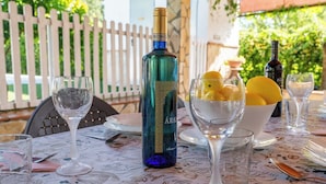 A table set with a bottle of wine, glasses, and a bowl of fruit. - PaperoDor Prado del Rey by Ruralidays (Cádiz)