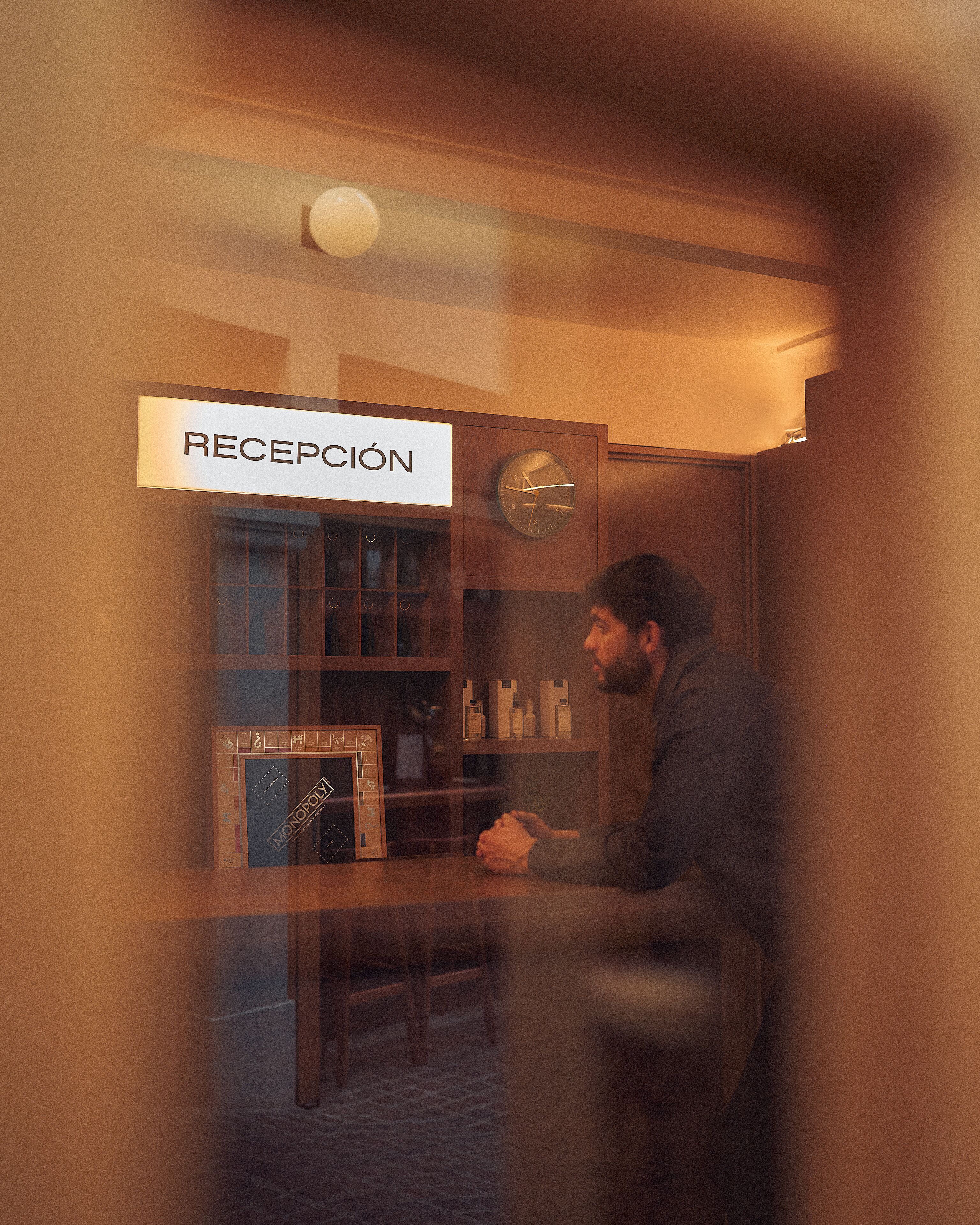 Un espace d’accueil avec une enseigne indiquant « RÉCEPTION » et une horloge au mur.
