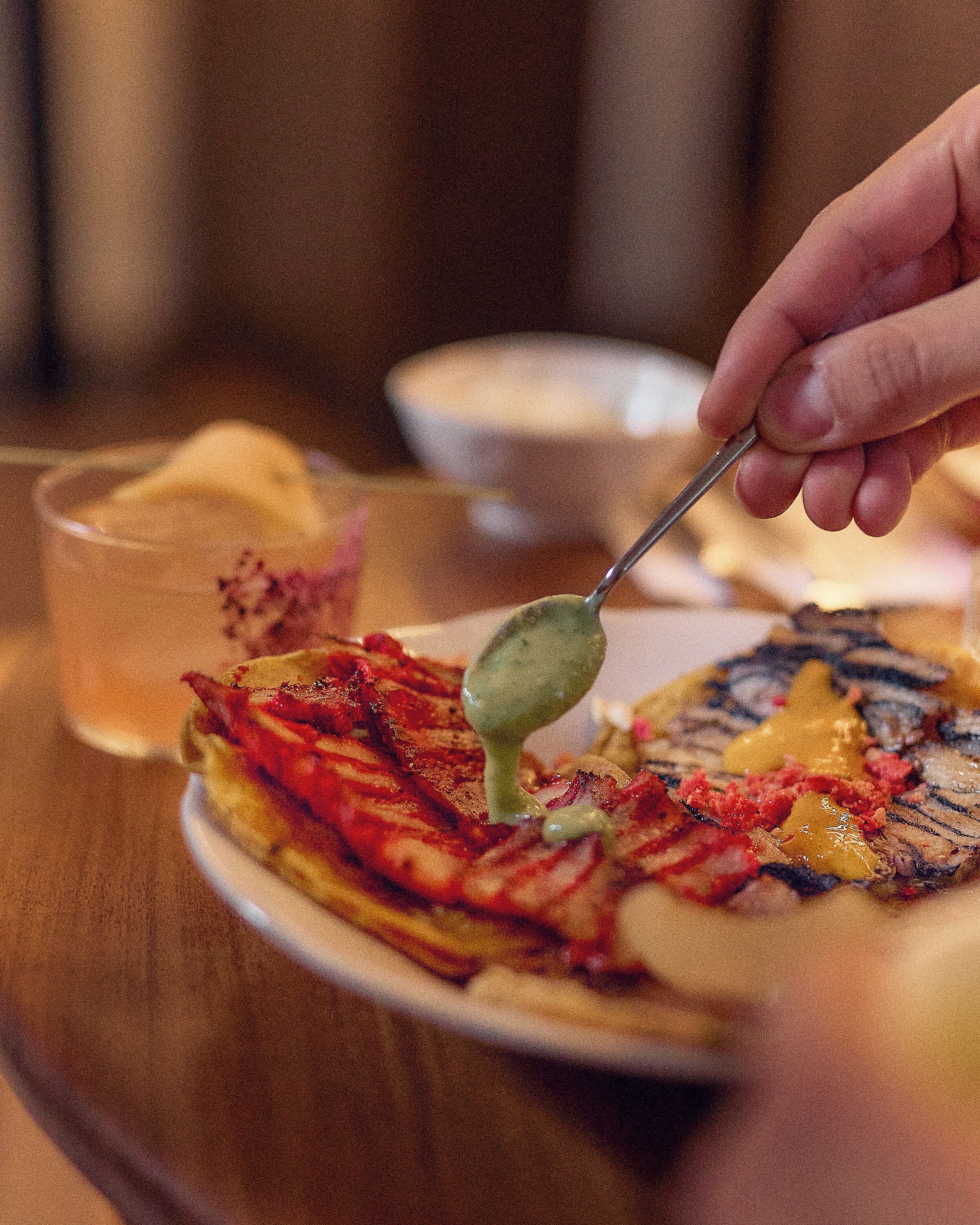 A person using a spoon to serve food from a plate.