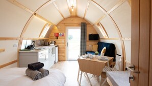 Una habitación acogedora y funcional, con cama, escritorio pequeño y una silla.