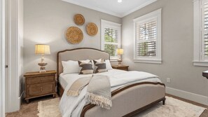 A bedroom with a bed, nightstands, and wall decor. - Back to the Beach by Avantstay with Pool Access (Santa Rosa Beach)