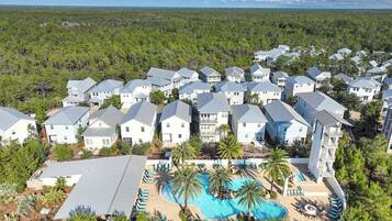 Un quartier résidentiel comprenant plusieurs maisons, une piscine et offrant une vue sur la forêt environnante.