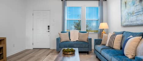 Een woonkamer met twee banken, een salontafel en een lamp.