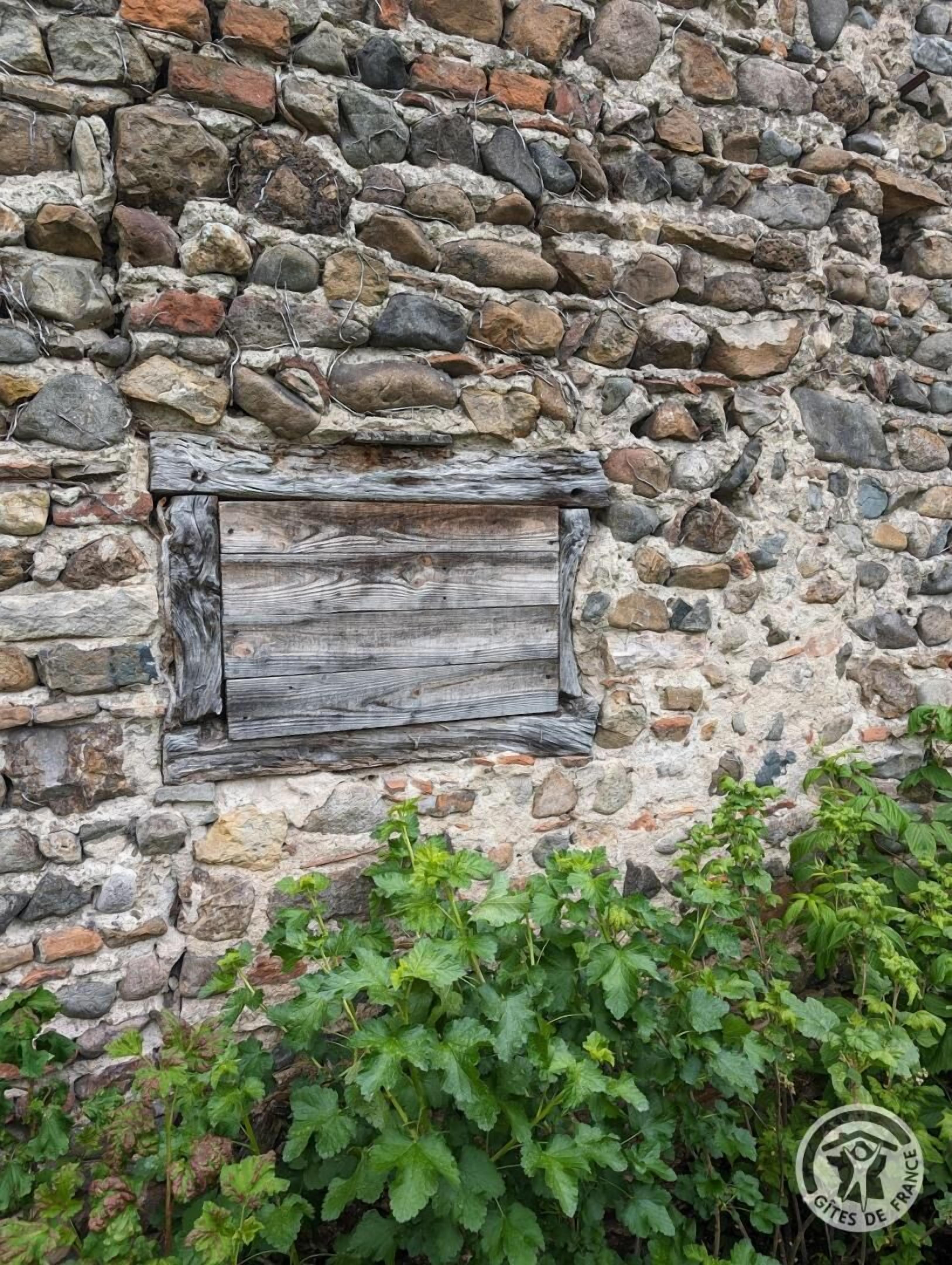 Un muro de piedra con una placa de madera.