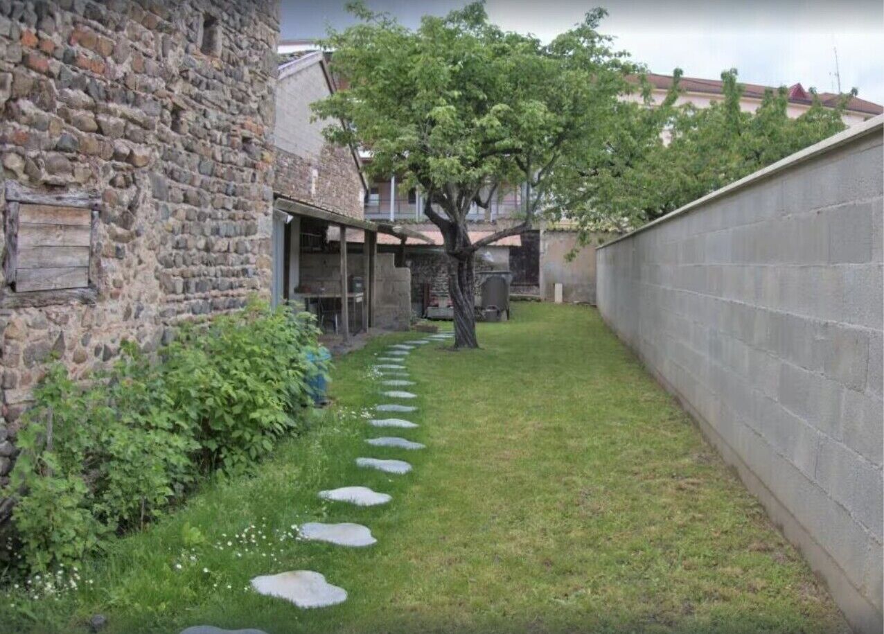 Un edificio de piedra con un sendero empedrado que lleva a una zona cubierta.