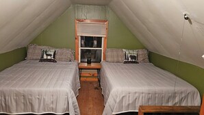 A small, cozy room with two beds, a window with blinds, and a wooden table. - 1-bedroom cabin in Redfield (Redfield)