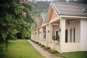 Una hilera de edificios blancos con tejados inclinados, cada uno con un balcón y un pequeño jardín.