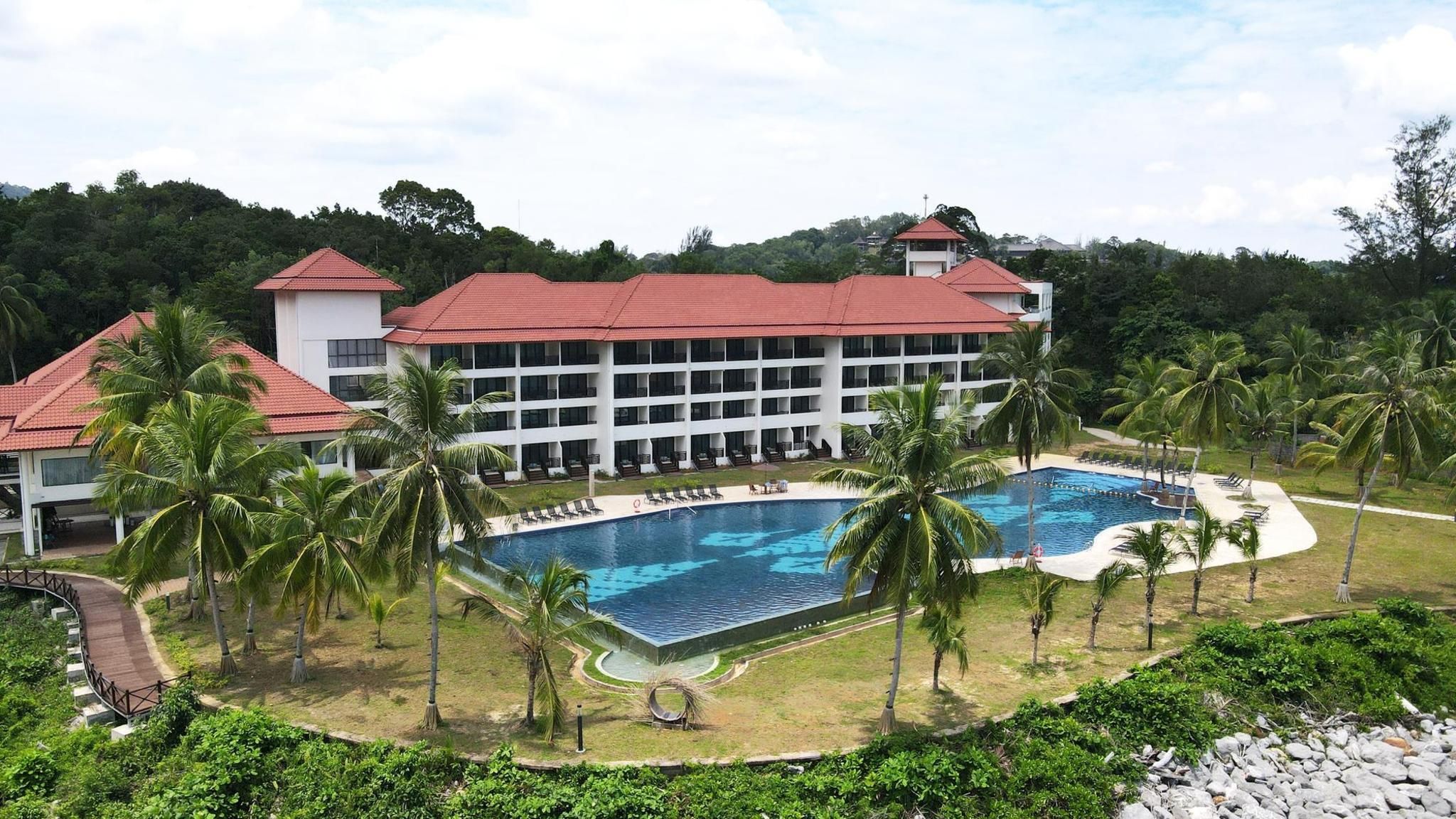 A resort with a large pool, palm trees, and a building with multiple balconies.