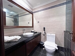 A bathroom with a round sink, a toilet, a trash bin, and a mirror. - Damai Lagoon Resort (Kuching)