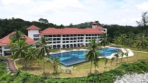 A resort with a large pool, palm trees, and a building with multiple balconies. - Damai Lagoon Resort (Kuching)