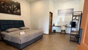 A bedroom with a bed, a desk, and a chair. - Raintown Cottage (Tupai)