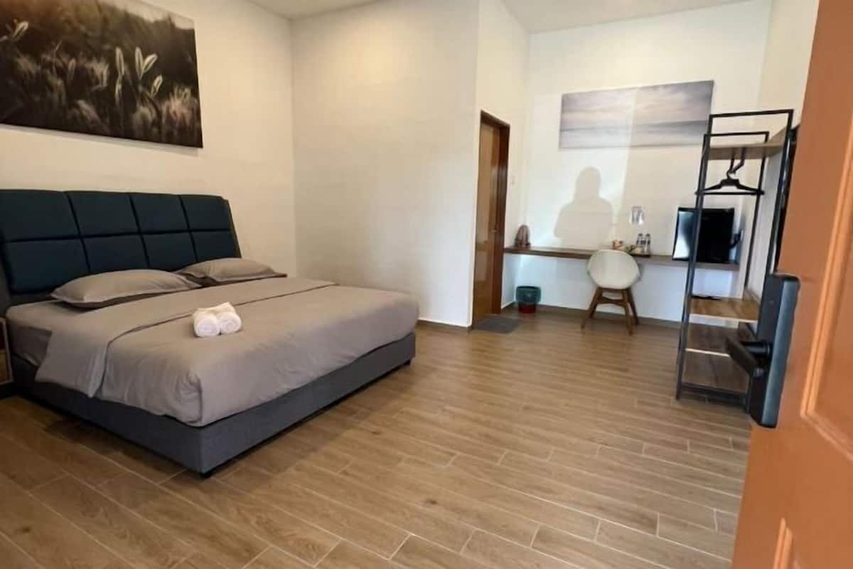 Ένα υπνοδωμάτιο με ένα κρεβάτι, ένα γραφείο και μια καρέκλα.