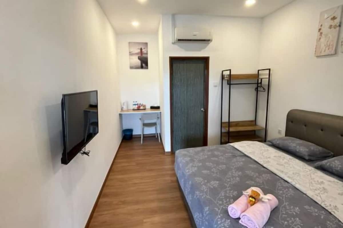 Ένα υπνοδωμάτιο με ένα κρεβάτι, ένα γραφείο, μια καρέκλα, μια τηλεόραση, κουκέτες και μια πόρτα.