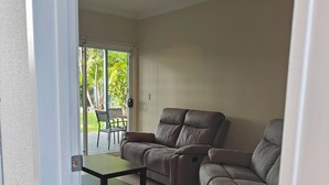 Ein Wohnzimmer mit Deckenventilator, einer Couch und einem Tisch.