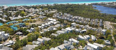 An aerial view of a residential area with houses, trees, and a coastline.