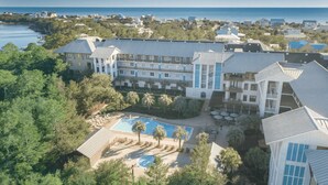 A resort with multiple buildings, a swimming pool, and a view of the ocean. - Smurf Mountain by Avantstay Private Beach + Pool Redfish Village (Santa Rosa Beach)