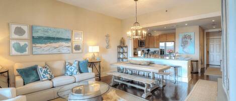 A spacious living room with a sofa, coffee table, and a dining area with benches.