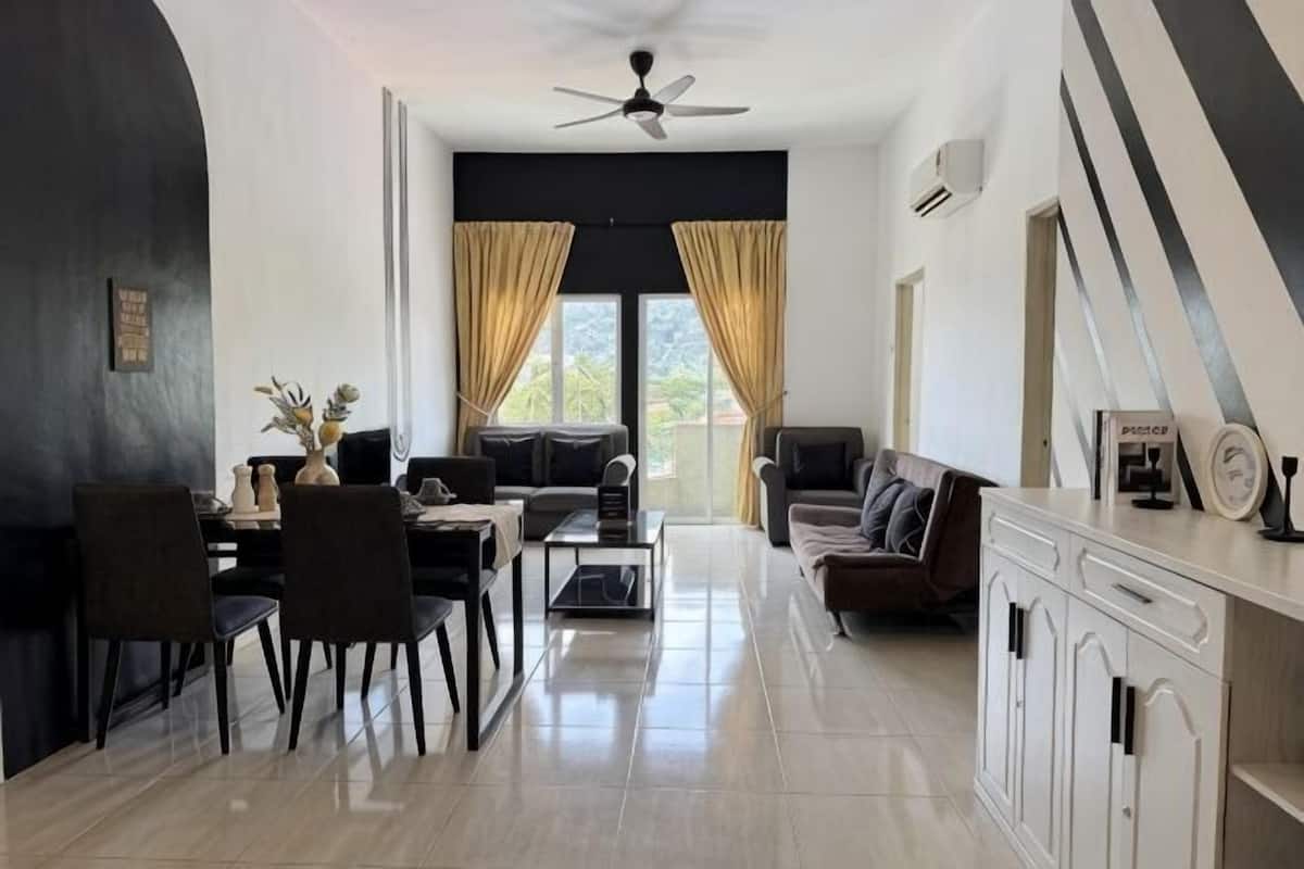 Un salon moderne comprenant un canapé, une table à manger, des chaises et un ventilateur de plafond.