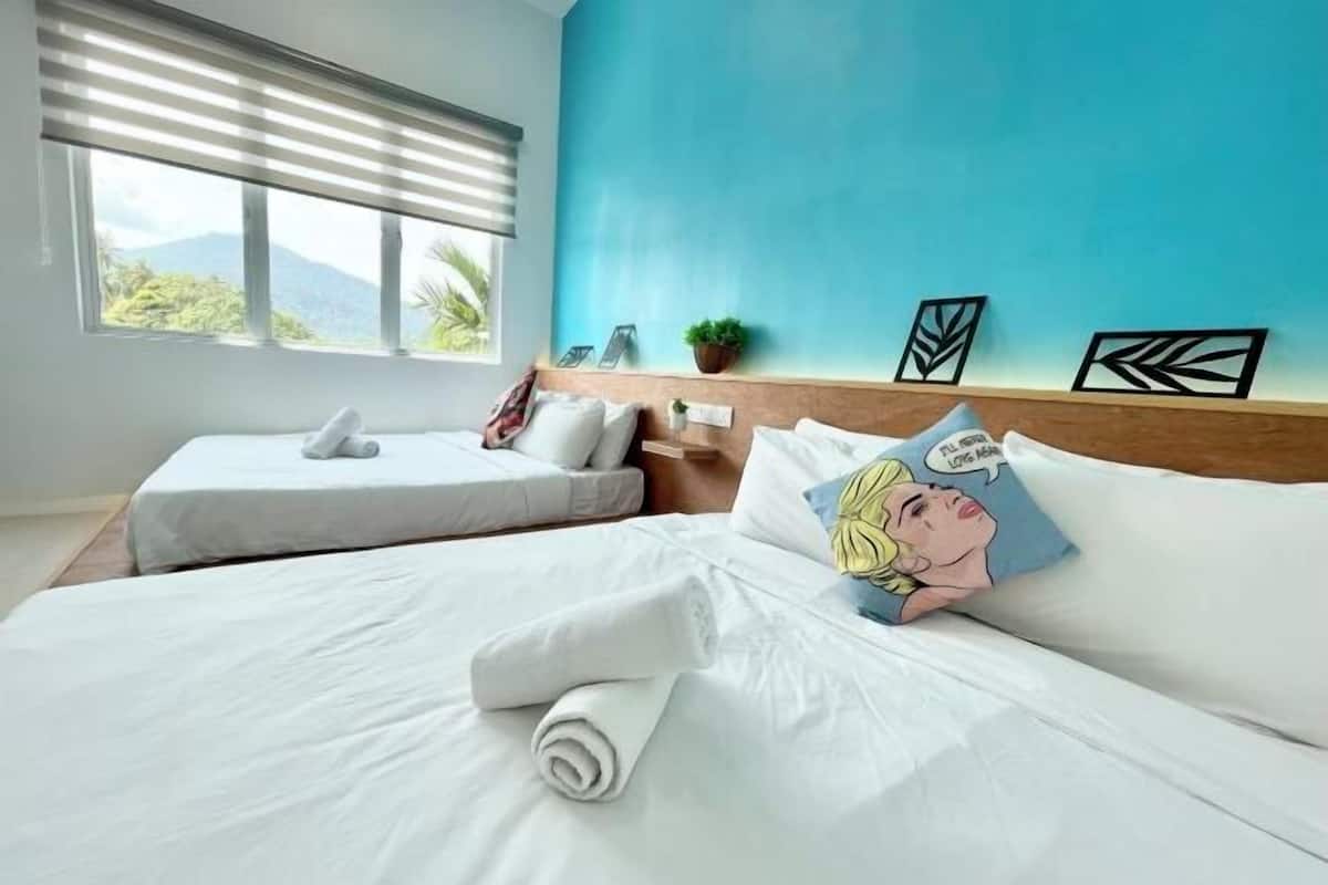 Une chambre d’hôtel avec deux lits, une vue sur les montagnes et un mur d’accent bleu.