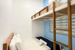 A bunk bed room with a wooden headboard, a single bed with a pillow, and a window with blinds. - The Cube Langkawi (Langkawi)