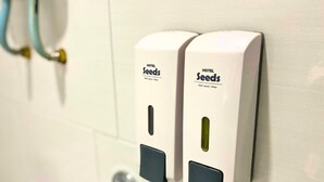 Two Hotel Seeds hand sanitizer dispensers mounted on a tiled wall. - Seeds Hotel Puchong Koi (Puchong)