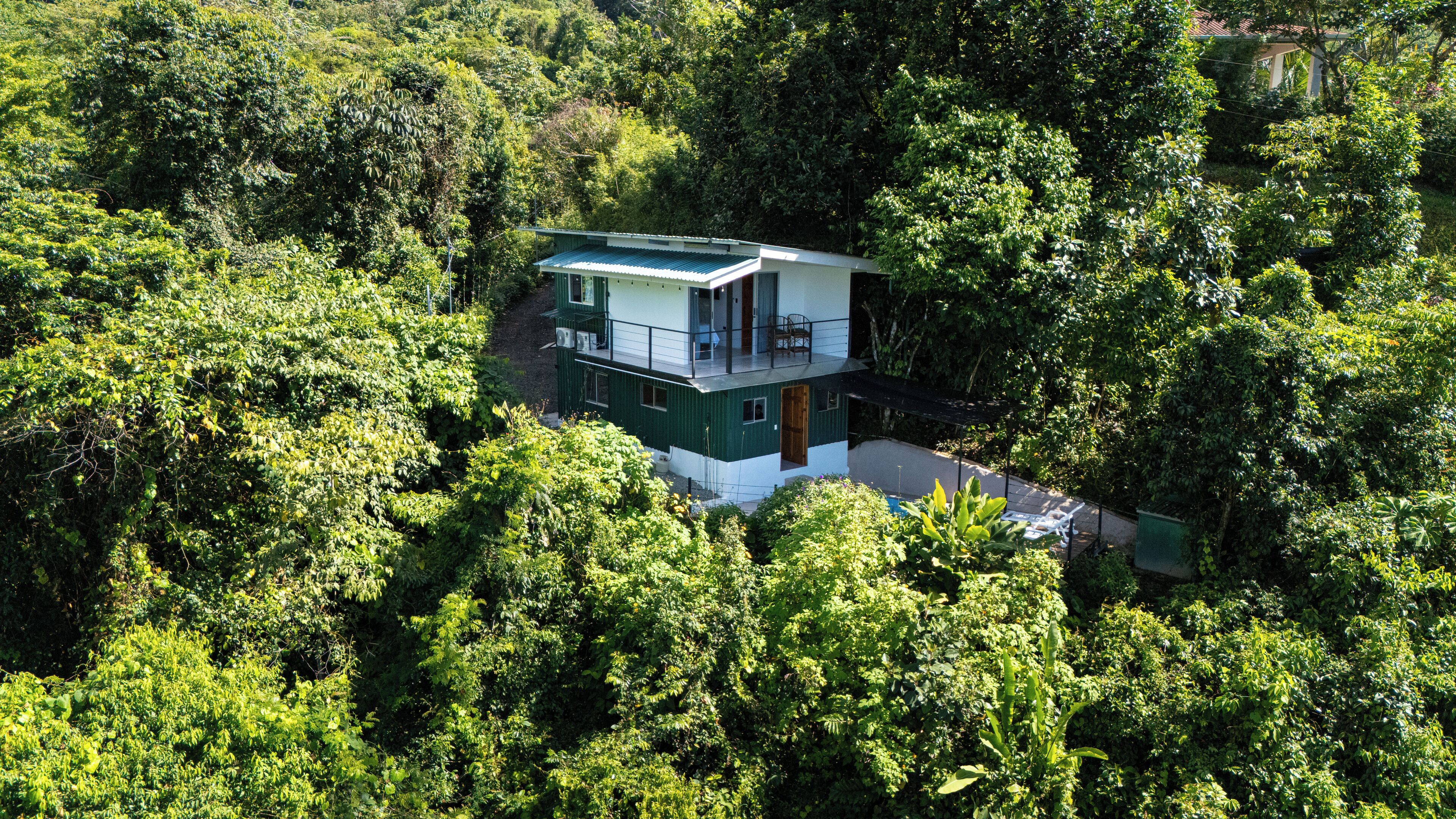 Un edificio de dos plantas rodeado de un bosque frondoso.