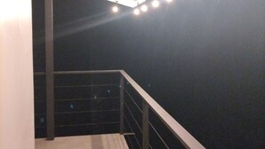 A balcony with a metal railing and a white awning.