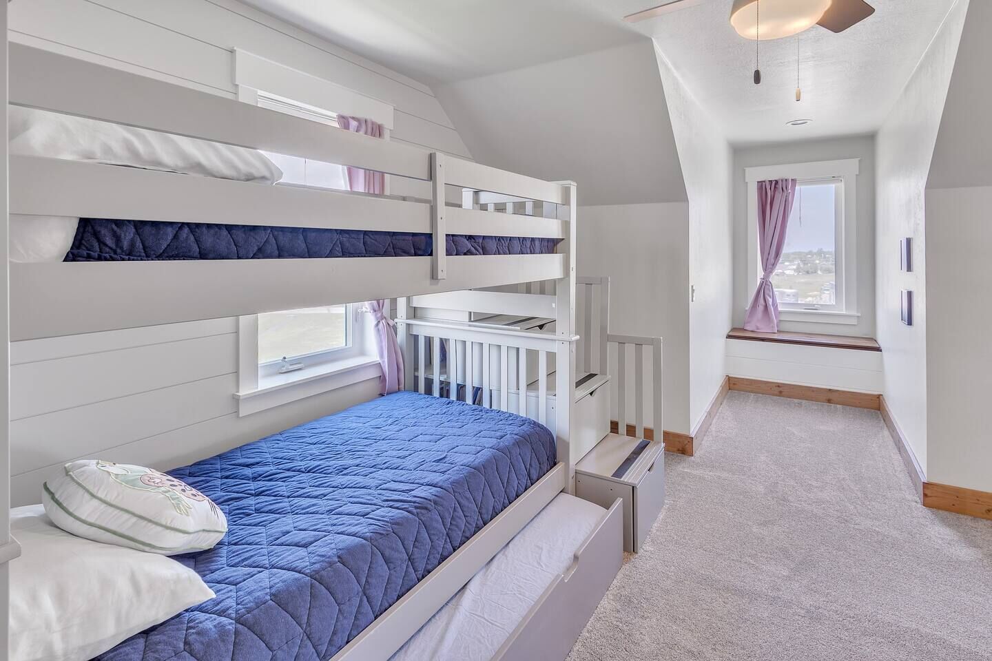A bunk bed room with a view of the city through a window.