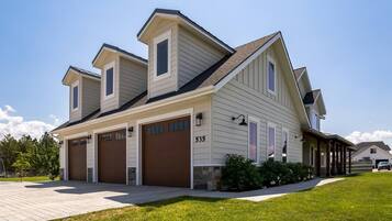 A two-story house with a garage, a covered porch, and a well-maintained lawn.