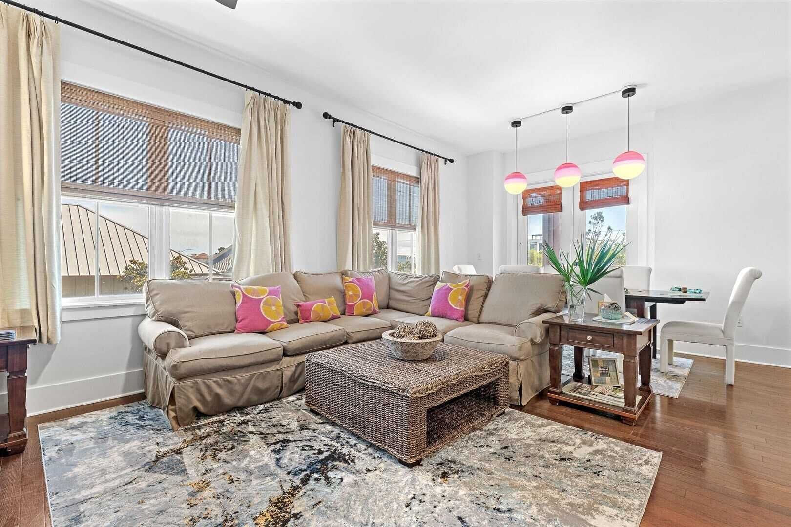 Una sala de estar moderna con un sofá modular, una mesa de centro y un comedor con mesa y sillas.