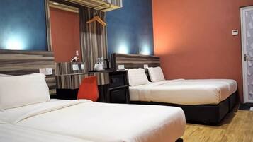 A hotel room with two beds, a desk, a chair, and a mirror.