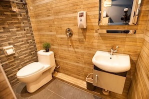 A bathroom with a toilet, sink, and mirror. - DJ Citi Inn Premier (Kuala Terengganu)