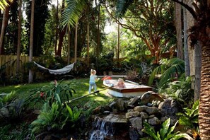 A garden with a hot tub, a hammock, and a small waterfall. - Luxico's Costa Rica in Byron (Byron Bay)