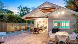 Ein Haus mit Pool, Außenbereich und überdachter Terrasse.