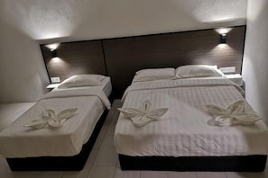 Two twin beds with white linens and floral bedspreads, a dark headboard, and wall-mounted lighting. - Luna Guesthouse (Semporna)