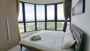 Un dormitorio con un ventanal grande, una cama y vistas a la ciudad.