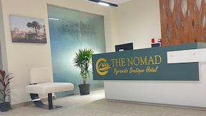 A reception desk with a sign for "The Nomad Pyramids Boutique Hotel". - The Nomad Pyramids Boutique Hotel (Giza)