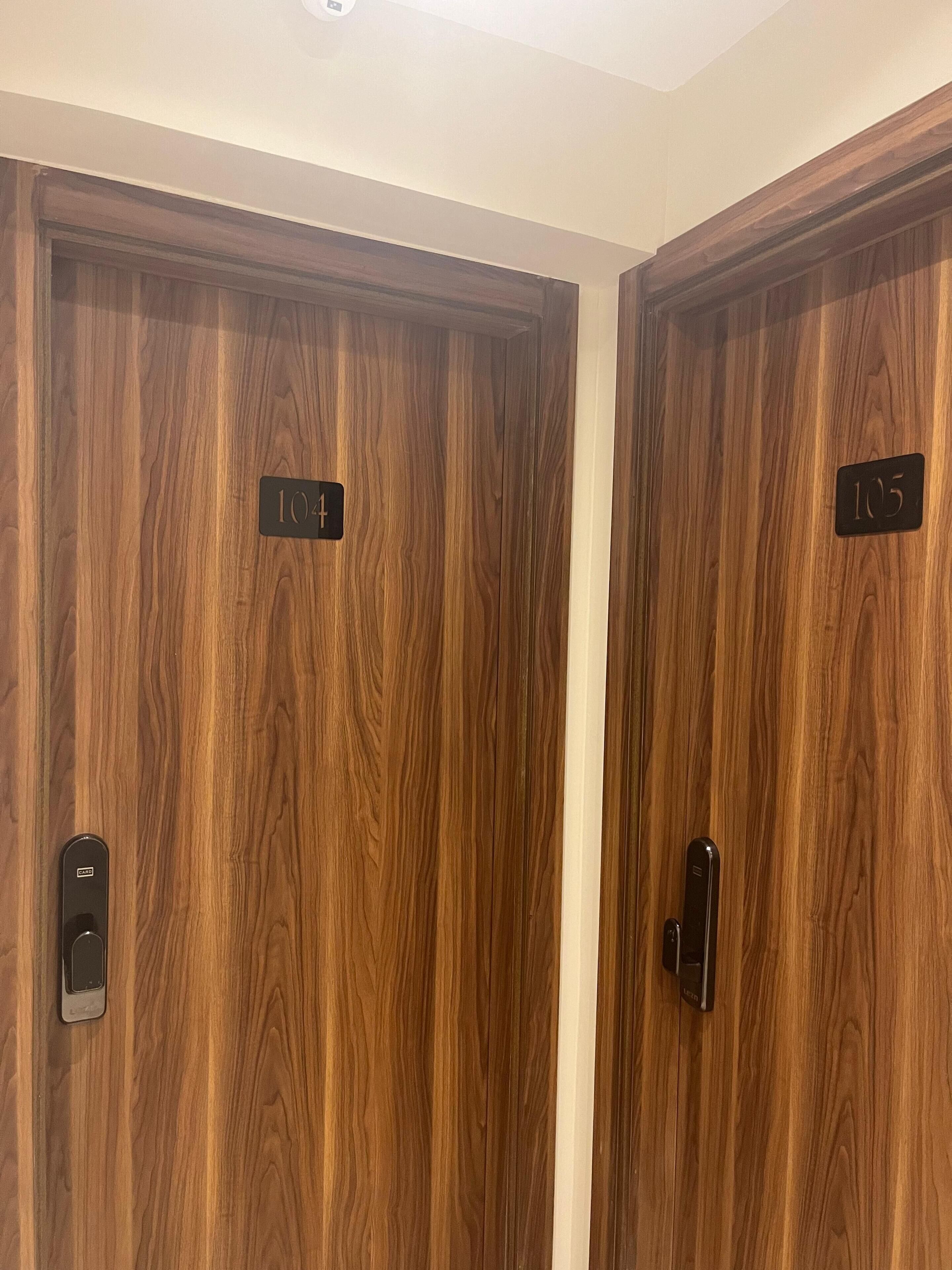 Dos puertas de madera con los números 104 y 105, que indican los números de habitación.